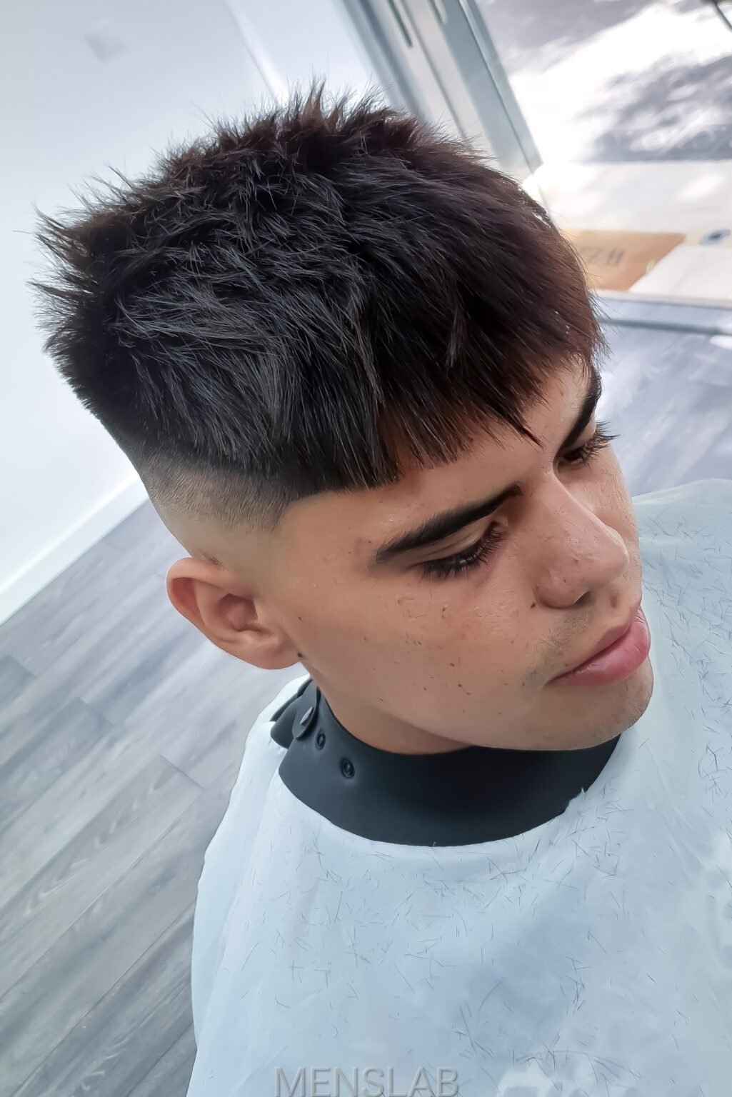Barbero cortando el pelo a un niño en Men's Lab Barcelona
